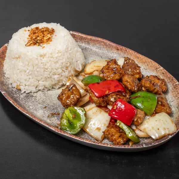 Sweet and sour chicken with red and green bell peppers, onions, and a side of white rice.