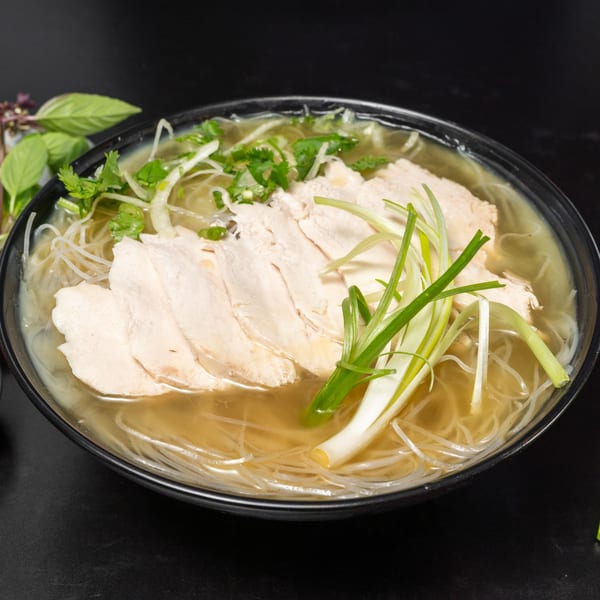 A bowl of Pho Ga from Pho Tick Tock, with chicken, noodles, broth, and green onions.