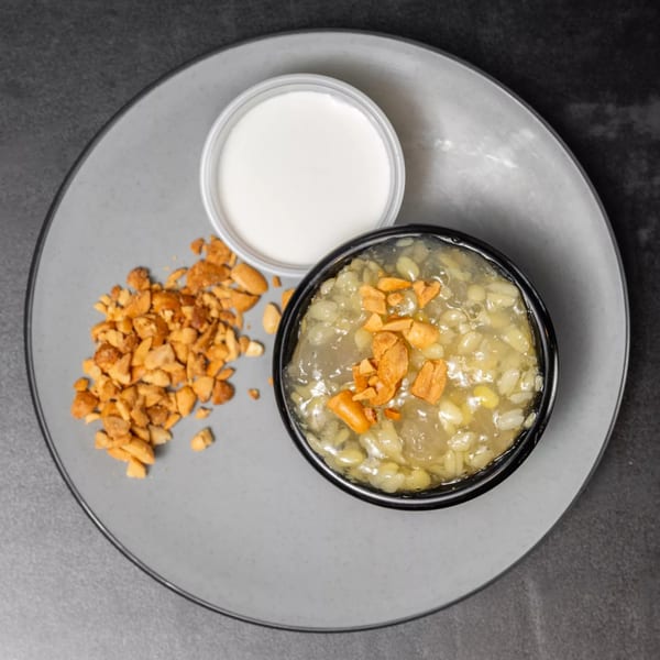 Vietnamese dessert with mung bean and tapioca, topped with peanuts, served with coconut milk.