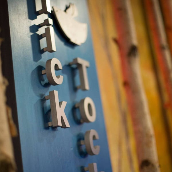 Close-up of the "Pho Tick Tock" sign with raised silver letters on a blue background.